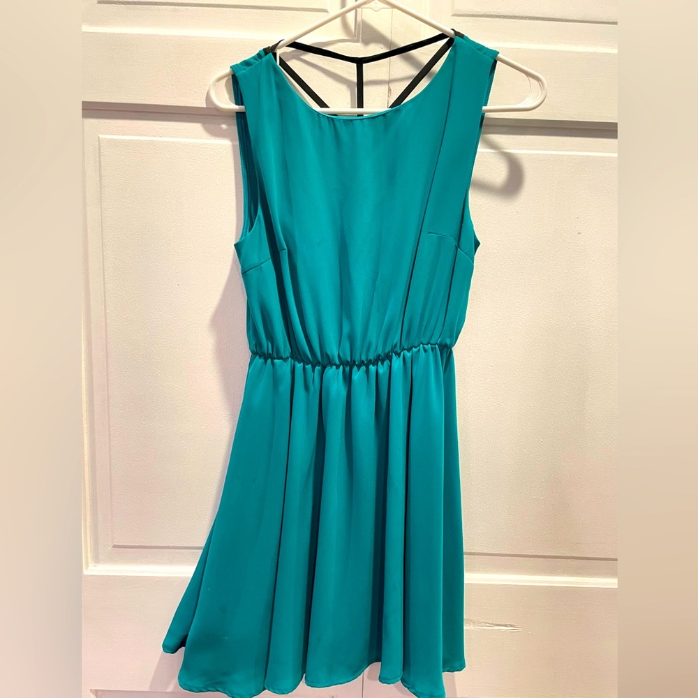 Light blue mini skirt flowy dress. Open back with black straps across.
